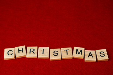 the word Christmas composed of wooden letters on a red background
