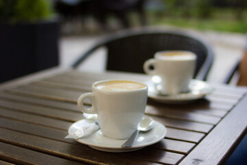 Two cups of coffee in wooden table at a bar terrace in Spain