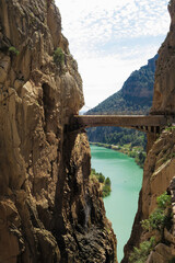 Fototapeta premium View of wooden bridge by cliffs and lake in El camito del Rey