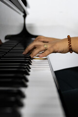Fototapeta premium Middle Eastern female hands playing piano in conservatory