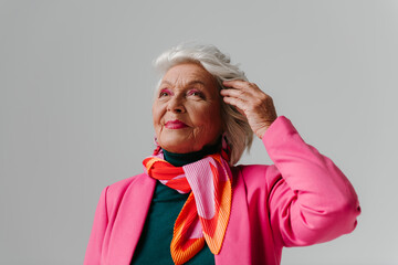 Fashionable senior woman radiating confidence and self-love while adjusting gray hair 