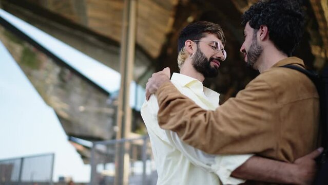 Two men in love, sharing close and joyful embrace, their faces lit with happiness of being together. ender moment between two men in a loving embrace, exchanging a gentle kiss with smiles