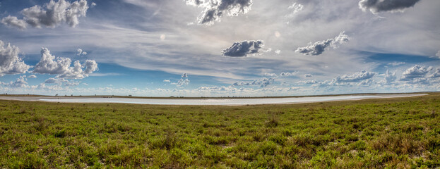 landscape, typical terrain often seen in southern africa, lake and savannah with a cloudy sky