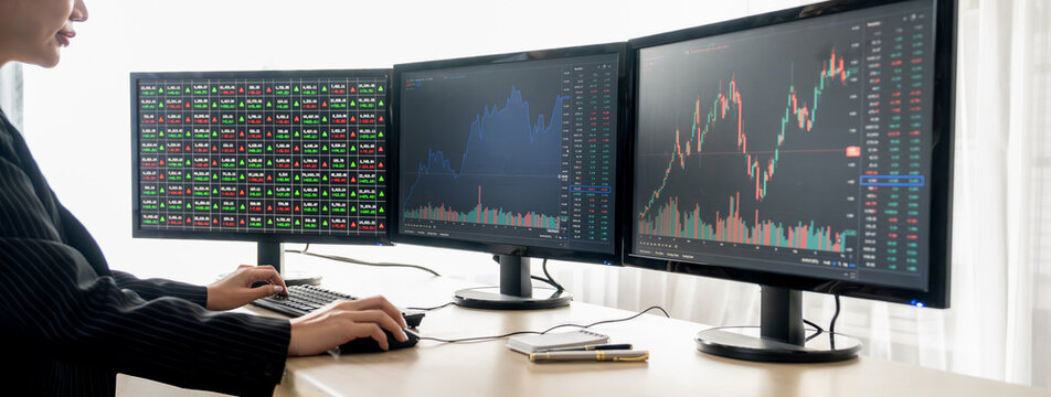 Cropped image of smart businesswoman analysis stock market data report while looking at computer screen. Young beautiful investor sitting while looking trading chart show increasing graph. Burgeoning.
