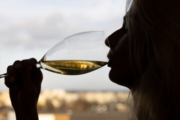 Woman drinking white wine, silhouette with glass - obrazy, fototapety, plakaty
