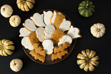 Scary Halloween cookies with icing sugar on a plate on a dark background