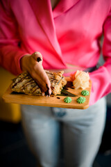 Female hand in a pink shirt imitates cutting a sushi sandwich in half