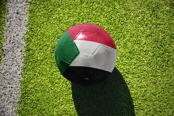 football ball with the flag of sudan on the green field near the white line