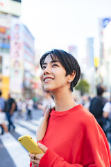 スマホを持って街を歩く女性
