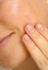 Close up of woman using moisturising skin serum on her face