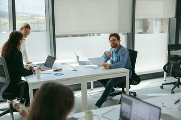 Business people working with laptops in office on colleagues background. Teamwork concept