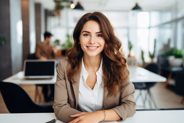 beautiful happy brunette woman looking at camera while sitting at the office