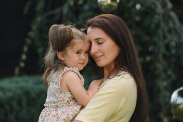 Portrait of mother with her cute daughter in park