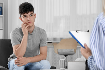 Obraz premium Psychologist working with teenage boy in office. Teenager problems