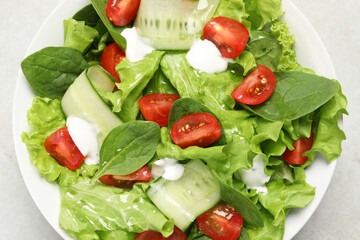 Delicious vegetable salad on light grey table, top view
