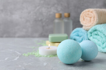 Beautiful aromatic bath bombs on light grey table, space for text