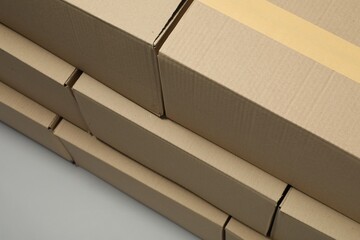 Stack of many closed cardboard boxes on light grey background, above view