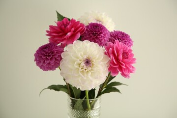 Bouquet of beautiful Dahlia flowers near white wall, closeup
