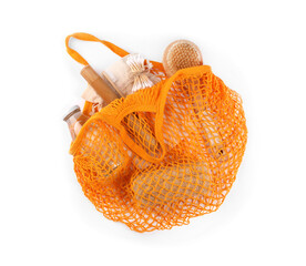 Mesh bag with different items isolated on white, top view. Conscious consumption