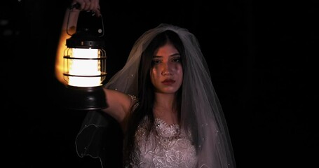 Scary Asian girl in Halloween bride dress costume in the dark forest.