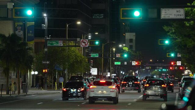 Urban road intersection with traffic lights and moving cars at night in American city. Transportation system in USA