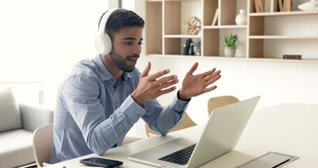 Moroccan business man talks to client remotely using laptop and video call application engaged in virtual meeting conversation, explain services details to customer, working using modern wireless tech