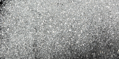 Explosion metallic silver glitter sparkle. Silver Glitter powder spark blink celebrate, blur foil explode in air, fly white glitters particle. Black background isolated, selective focus Blur bokeh