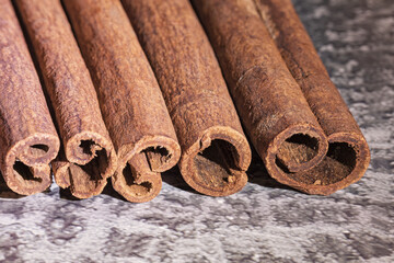 fragrant cinnamon sticks on a brown-gray background, photographed in close-up