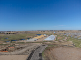 Drone view over two grain storage piles being filled and covered