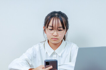 Fototapeta premium PCとスマホを操るメガネ女子