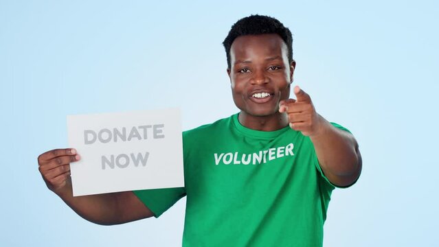 Face, black man and hand pointing to donate poster in studio for ngo, platform or support on blue background. Charity, banner and portrait of African volunteer with community service, news or info