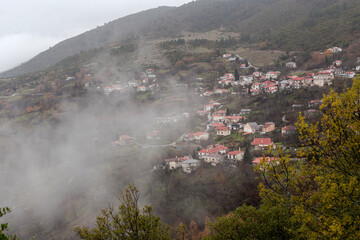 View of the village (Greece, Epirus) and snow-covered mountains in a winter on a cloudy day
