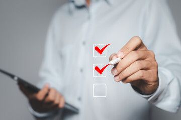 Businessman ticks checklist and takes online assessment survey test for approve business project. Quality assurance and ISO guarantee, Checklist concept.