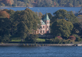Pink waterfront conference building with tower in the ness Täcka Udden, a sunny colorful autumn...
