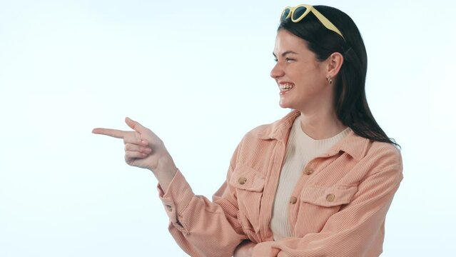 Thinking, space and smile with a woman pointing on a blue background in studio for inspiration. Idea, wow or surprise with a happy young person looking excited by a memory or eureka moment on mockup