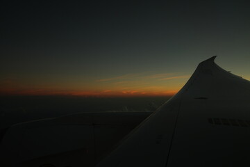 Fototapeta na wymiar Sunrise from Airplane Window - 飛行機からの景色 朝日