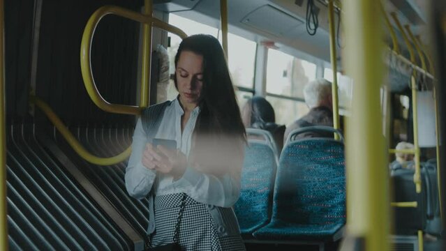Beautiful young woman standing in city bus