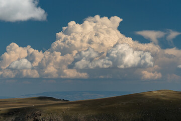 Fototapeta na wymiar Hills and large cumulonimbus clouds
