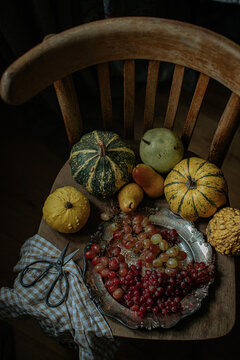 Pumpkin, grapes and pears on wooden chair