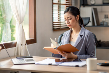 Fototapeta na wymiar Young business asian woman working at home with laptop and papers on desk