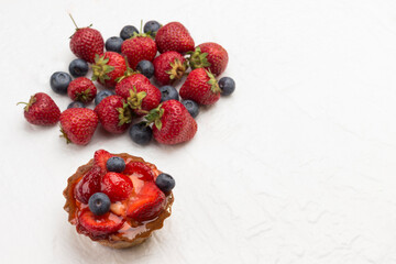 Tart decorated with fresh berries. Strawberry and blueberries on white background.