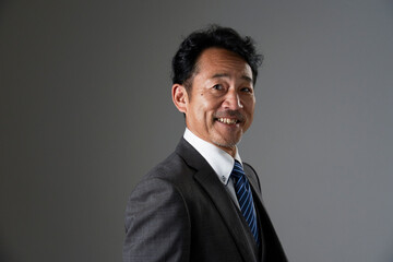 笑顔の中年のビジネスマンのポートレート　黒背景　カメラ目線