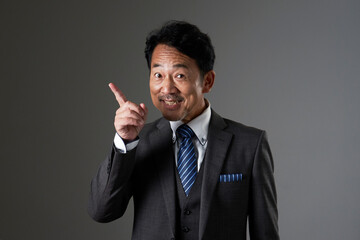 左側を指差す中年のビジネスマン　黒背景