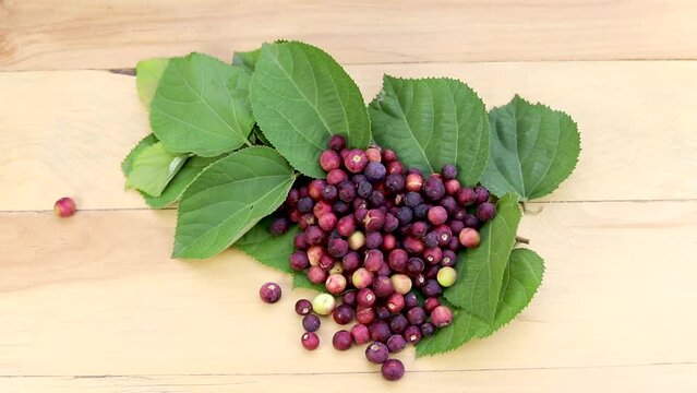 Ripe flasa fruit with green leaves on a wooden table