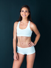 Fototapeta premium Happy woman, portrait and fitness to lose weight, health and wellness against a studio background. Active female person smile with hand on hip for body workout, exercise or training on mockup space