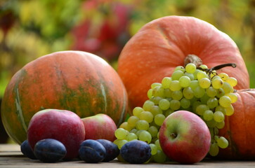 Assortment of fruits, grapes and nuts. Autumn seasonal harvest. pumpkin apples, red, yellow leaves. food still life with season fruits. Thanksgiving day, Halloween decoration fall design