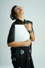 Beautiful Indian young woman in a saree using her laptop, working from home