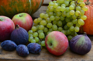 Assortment of fruits, grapes and nuts. Autumn seasonal harvest. pumpkin apples, red, yellow leaves. food still life with season fruits. Thanksgiving day, Halloween decoration fall design