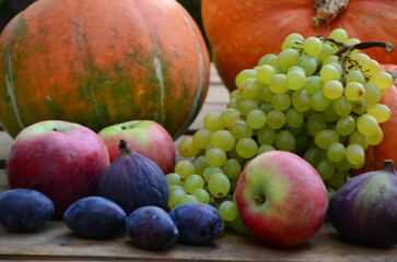 Assortment of fruits, grapes and nuts. Autumn seasonal harvest. pumpkin apples, red, yellow leaves. food still life with season fruits. Thanksgiving day, Halloween decoration fall design