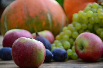Assortment of fruits, grapes and nuts. Autumn seasonal harvest. pumpkin apples, red, yellow leaves. food still life with season fruits. Thanksgiving day, Halloween decoration fall design